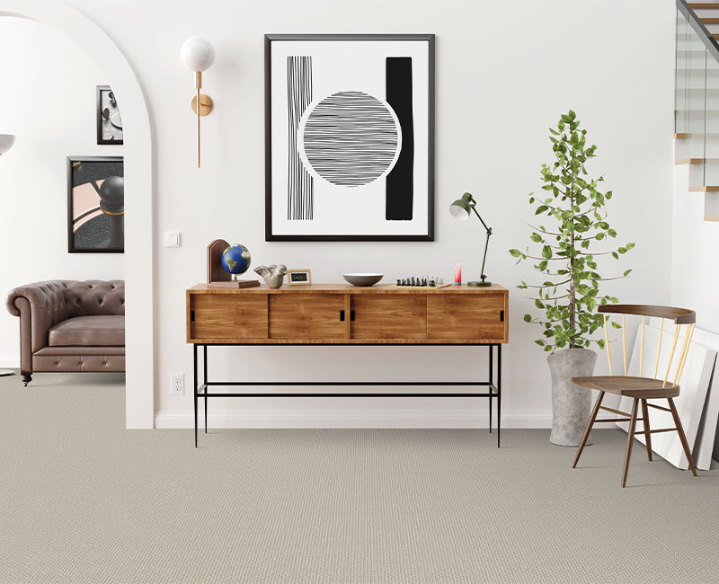 grey carpet in entryway with table and decor